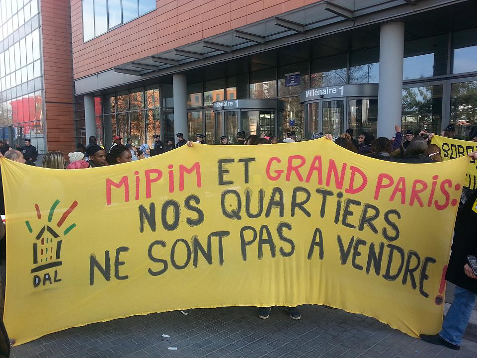 Une banderole sur laquelle il est écrit : "Mipim et Grand Paris, nos quartiers ne sont pas à vendre"